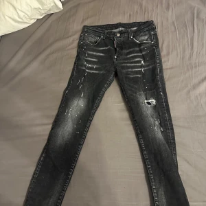 Svarta jeans från Dsquared2 - Snygga svarta jeans från Dsquared2 med slitna detaljer och en cool, tvättad look. De har en knappgylf och klassisk femficksdesign. Perfekta för en trendig stil.