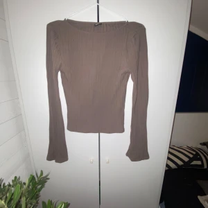 Brun ribbad topp från Gina Tricot - Säljer en enkel brun ribbad topp från Gina Tricot. 💃Toppen har långa ärmar som visas ut och en enkel design som passar perfekt till olika outfits.😉 Perfekt för dig som gillar en minimalistisk stil.🙃🙂