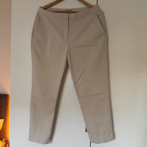Beige kostymbyxor - Beige kostymbyxor med en rak passform och fickor på sidorna. Strl 42