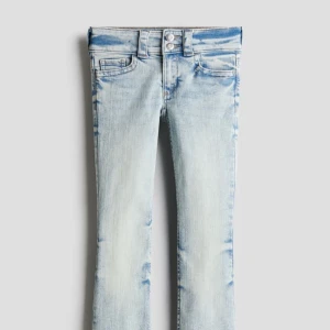Ljusblå bootcut jeans - Snygga ljusblå bootcut jeans med en klassisk femficksdesign och knappdetaljer. Jeansen har en justerbar midja för perfekt passform. Perfekta för en avslappnad stil. Köpta för 279kr. Använd några få gånger.