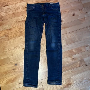 Blå jeans Crocker Pep Skinny - Snygga blå jeans från Crocker (Pep skinny) med en klassisk femficksdesign och dragkedja. Jeansen har en normal passform och är perfekta för en avslappnad stil. De har en lätt tvättad look som ger en cool touch.