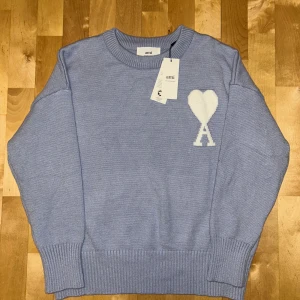 Ami Paris Tröja - Säljer en snygg ljusblå stickad tröja från Ami Paris. I perfekt skick då den aldrig använts, pga för liten storlek. Det är storlek S men sitter mer som en XS enligt mig. Är öppen med prisförslag och andra funderingar, då tveka inte på att kontakta.