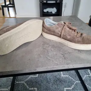 Snygga bruna sneakers i mocka från Vagabond som är köpta för 1300. De har en klassisk design med snörning och en vit sula som ger en stilren look. Perfekta för nästan allt och get mycket stockholmsstil.