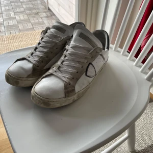 Philip model  - Snygga vita sneakers med grå detaljer och snörning. Skorna har en klassisk design med en rund tå och en bekväm passform. Perfekta för en avslappnad stil. Skick 7/10 Allt og ingår. Pris kan diskuteras vid snabb affär. 