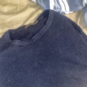 Mörkblå Kashmir-crewneck från Oscar Jacobson - Säljer en stilren mörkblå tröja från Oscar Jacobson. Tröjan är tillverkad i en mjuk blandning med 50% kashmir, vilket gör den både varm och bekväm. Perfekt för kyligare dagar. Nypris: 1500kr