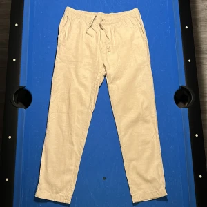 Beige linnebyxor - Säljer ett par beige linnebyxor med elastisk midja och snörning. Storlek L