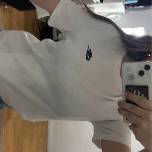 Vit t-shirt från Nike - Säljer en klassisk vit t-shirt från Nike med den ikoniska loggan på bröstet. T-shirten är kortärmad och tillverkad i mjuk bomull, perfekt för en avslappnad stil. Kommer ej till användning 🥰🥰💞💞🌅❄️☀️ ganska stor på mig