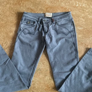 Grå low waist jeans - Snygga grå low waisted straight/flare jeans från Phard köpt begagnade med guld broderade detaljer på bakfickorna. Storlek 29, innebens längd 80 cm💕