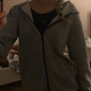 Grå hoodie från Andy by Frank Dandy - Säljer en grå hoodie från Andy by Frank Dandy. Den har en dragkedja framtill och en bekväm huva. Perfekt för en avslappnad stil. Den är supervarm till vintern 
