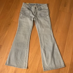 Ljusblå lågmidjade bootcut jeans från Mossimo Supply Co. - Snygga ljusblå bootcut jeans från Mossimo Supply Co. I nyskick. Så najs fickor och detaljer. Mått, längd: 94. Midja:78. Höfter:90