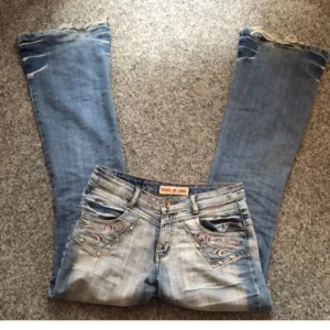 Blå jeans med broderi - Snygga blå jeans med unikt broderi på bakfickorna och över bakstycket. .jag säljer på grund av att dem är förstora, köpta för ungefär 400 med frakt. Säljer för 150. Litet hål i sig så om ni vi ha bild på det skickar jag. Men det syns inte!! Obs‼️Hål. Har inte en bild på det så hör av er I  St 38, M-S. Endast instabox. Bilderna är från gamla ägaren!