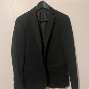 Svart kavaj från Jack & Jones - Snygg svart kavaj från Jack & Jones. Använd endast en gång så den är i toppskick. Sitter som en xs/s i storlek