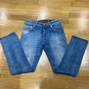 Jacob cohen jeans - Snygga blå jeans från Jacob Cohen med klassisk femficksdesign och orangea sömmar. De har en normal passform och är tillverkade i slitstarkt denim. Perfekta för en avslappnad stil. Pris kan diskuteras vid snabb affär