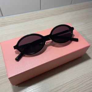 Svarta chic solglasögon  - Snygga svarta solglasögon som liknar de ikoniska miumiu med sin runda form. De har en stilren design och kommer i en kartong med en duk. Perfekta för att ge en cool touch till din outfit. Observera att boxen på bilden inte ingår och är endast för bilden.