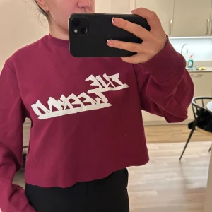 The weeknd Vinröd croppad tröja från H&M - Säljer en vinröd croppad tröja från H&M med trycket 'The Weekend' i vitt. Tröjan har långa ärmar och ribbade muddar vid ärmslut. Perfekt för en avslappnad stil.