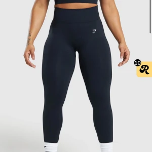 Gymshark tränings tights - Modell: Lift seamless leggings. Helt oandvända snygga och bekväma mörkblåa seamless leggings med lyftande passform. Perfekta för träning eller en avslappnad dag. De är högmidjade och tillverkade i ett stretchigt syntetmaterial som ger bra rörelsefrihet.