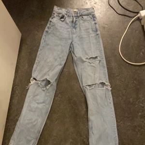 högmidjade/high waist ripped jeans  - ljusblåa high waist jeans med hål i sig från gina tricot! har ett smått hål i sig i sidan men syns inte om man inte kollar riktigt noga. de är lite långa på mig som är 154cm men är inte direkt störigt