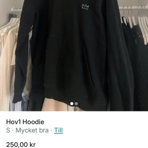 Svart Hov1 Hoodie - Säljer en svart Hov1 hoodie med en liten krona tryckt på framsidan och turnédatum på baksidan. Hoodien har en klassisk passform med långa ärmar och en stor ficka framtill. Perfekt för fans av Hov1! 🖤
