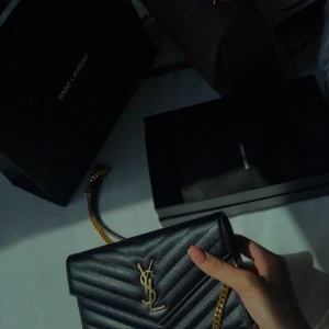 Svart axelväska från Saint Laurent - Säljer nu min Ysl väska ”Cassandre envelope chain wallet”.  Köpte den 2019 i Paris, endast använd vid fåtal tillfällen.   Kvitto, äkhetsbevis samt dustbag följer med.  Priset går att diakutera vid snabb affär!
