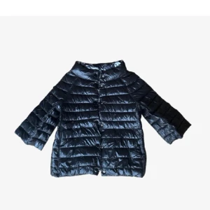 Svart trekvartsärmnad jacka  - Snygg svart trekvatsärmad jacka med blommig insida och knappar framtill. Jackan har en quiltad design, den har en normal passform och är både stilren och praktisk. Stl S/M