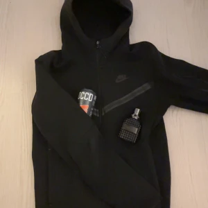 Nike tech hoodie - Säljer min svarta Nike tech hoodie då jag vuxit ur den. Den är i bra skick och inga synliga skador. Den är i storlek XS men kan även passa S:) pris kan diskuteras vid en snabb affär!