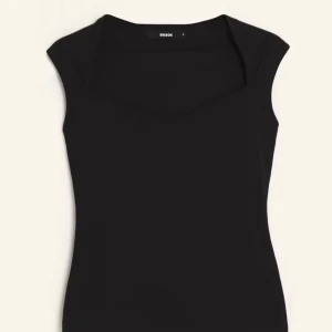 Svart ärmlös topp från Bik Bok - Snygg svart ärmlös topp från BikBok med en elegant fyrkantig urringning. Perfekt för att matcha med jeans eller kjol för en stilren look.