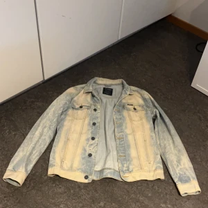 Ljusblå jeansjacka från Pull&Bear - Säljer en ljusblå jeansjacka från Pull&Bear i storlek M. Jackan har en klassisk design med knappar framtill och två bröstfickor. Perfekt för en avslappnad stil.