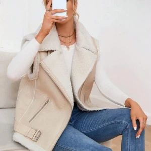 Beige pälsväst med dragkedja - Snygg beige pälsväst med dragkedja och bälte i midjan. Västen har en mjuk och fluffig insida som ger extra värme och stil. Perfekt för att lägga till en trendig touch till din outfit. Storlek L. Nypris 599. Mitt pris 400