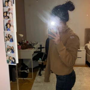 Beige tröja med dragkedja - Säljer en beige tröja med halv dragkedja och hög krage. Tröjan har långa ärmar och är perfekt för en avslappnad stil. Den är gjord i ett mjukt material som känns skönt mot huden.