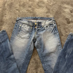 Blå Lågmidjade jeans - Skitsnygga lågmidjade jeans med coola fickor fram och bak. De är bootcut med snygg urtvättning. Passar strl xs och s. 
