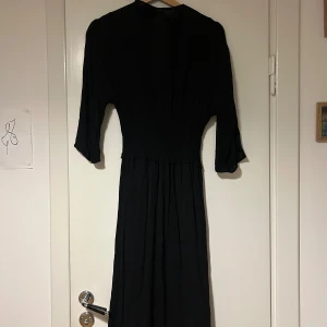Svart klänning från & Other Stories - Elegant svart klänning från & Other Stories med trekvartsärm. Inköpt för 1200 kr. 