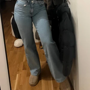 Blå jeans med hög midja - Snygga blå jeans med hög midja och en klassisk straight fit. Perfekta för en avslappnad stil. De har en traditionell femficksdesign och en knappgylf.