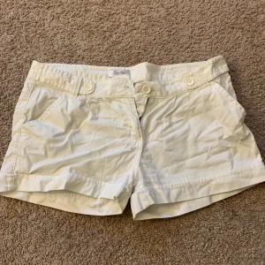 Lågmidjade vita jeans shorts från Pimkie - Snygga vita shorts från Pimkie med knappdetaljer framtill. De har en klassisk design med fickor på sidorna och en bekväm passform. Storlek 38