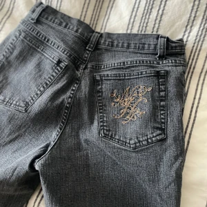 Jeans med broderad ficka - Skitsnygga jeans i en mörk grå-aktig färg. Har broderi på ena bakfickan. Storlek 36