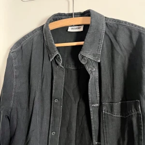 Denim skjorta - Mörkgrå jeans skjorta med långa ärmar i oversize! Skjortan är från Weekday, har använts fåtal gånger och har inga märken eller fläckar, väldigt fint skick! Alla använda plagg tvättas noga innan leverans! Det är bara att skriva om du har några frågor! <3 