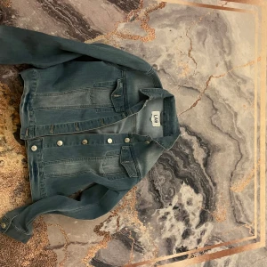 Blå jeansjacka - Snygg blå jeansjacka från LAB köpt från med klassisk design. Säljer för 40 och storleken är 157. Jackan har knappar framtill och två bröstfickor med lock.