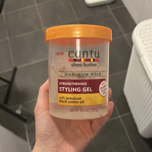 Cantu Shea Butter Styling Gel - Cantu Shea Butter Strengthening Styling Gel med jamaicansk svart ricinolja. Ger maximal stadga utan att klibba. Perfekt för att styla och vårda håret samtidigt.