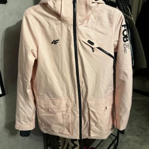 Ljusrosa skidjacka från 4F - Säljer en ljusrosa jacka från 4F med avtagbar huva. Jackan har två stora fickor framtill och en mindre bröstficka med dragkedja, även en längst nere på vänsterarm avsedd för liftkort. Perfekt för kyliga dagar med sin NEODRY-membran för extra skydd mot väder och vind. Den är i nyskick och endast testad! Nypris 1499 kr, priset kan diskuteras 😊 OBS den är mycket mer rosa i verkligheten!