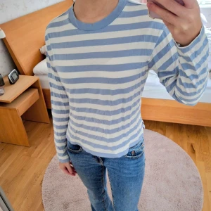 Blå- och vitrandig tröja från Monki - Blå- och vitrandig tröja från Monki. Tröjan har långa ärmar och en rund halsringning, avslappnad stil. Passar bra till jeans eller kjol. Jag är 163 cm. Tunn och skönt tyg!💙🤍