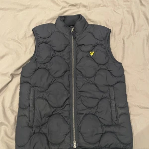 Marinblå quiltad väst från Lyle & Scott - Blå lyle and scott väst. Använd men inga tecken på det. Storlek xs. Nypris 1095kr. Perfekt nu till våren.