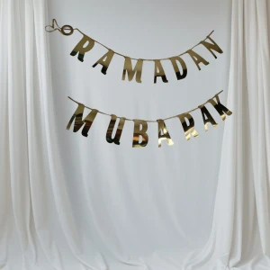 Guldglittrig Eid Mubarak girlang - Snygg och festlig girlang med texten 'Eid Mubarak' i glittrande guld. Bokstäverna är cirka 10 cm höga och 6 cm breda, perfekt för att dekorera ditt hem under Eid-firandet. Lätt att hänga upp och ger en lyxig känsla till din fest.