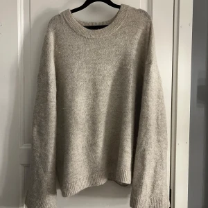Beige stickad tröja - Mysig beige stickad tröja med rund hals och långa ärmar. Perfekt för kyliga dagar och ger en avslappnad stil. Passar bra till jeans eller leggings för en bekväm look.