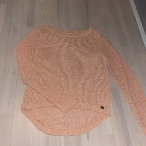 Persikofärgad stickad tröja från ONLY - Säljer en persikofärgad stickad tröja från ONLY. Tröjan har en rund hals och långa ärmar. Den har en enkel och stilren design som passar till många olika outfits💗