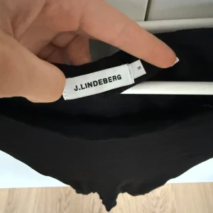 Svart topp från J.Lindeberg - Super fin topp från J. Lindeberg. Funkar perfekt till både fest och skola! Super casual men ändå snygg. Sitter skit bra och är normal i storleken.