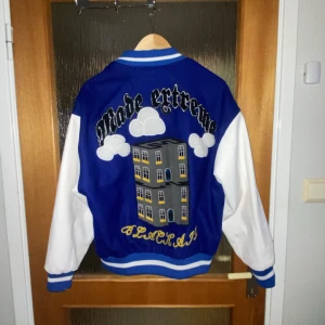 Blå och vit college jacka med broderi - Collegejacka i bra skick, säljes då den blivit för liten. (Kan säljas ihop med Scarface jackan)