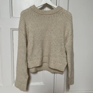 Stickad tröja från Gina tricot.  - Mysig beige stickad tröja från Gina Tricot i storlek XS. Tröjan har en slits vid midjorna och vid armarna.