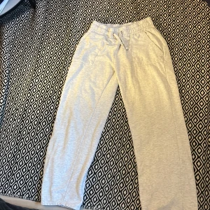 Grå mjukisbyxor med snörning - Säljer ett par bekväma grå mjukisbyxor med elastisk midja och snörning. Byxorna har en avslappnad passform och praktiska fickor fram och bak. Perfekta för en chill dag hemma eller en snabb tur till affären.