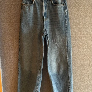 Blå jeans från Gina Tricot - Snygga blå jeans från Gina Tricot i en klassisk design. De har en hög midja och raka ben, vilket ger en tidlös look. Perfekta för en snygg vardagslook!