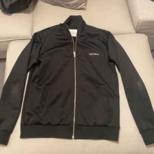 Overshirt  - Snygg svart overshirt från Les Deux med dragkedja framtill. Tröjan har en stilren design med ribbade muddar vid ärmslut och nederkant. L passar M