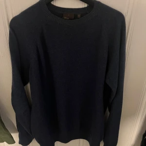 Mörkblå stickad tröja från Oscar Jacobson - Säljer en stilren mörkblå stickad tröja från Oscar Jacobson. Made in italy